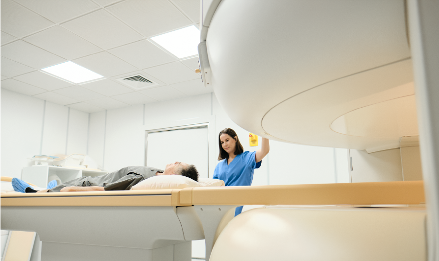 Technician operating medical imaging scanner with patient